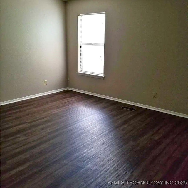 empty room with dark hardwood / wood-style floors