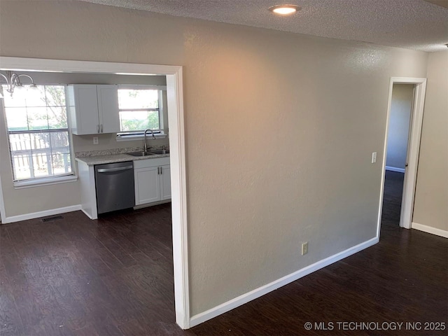 kitchen with sink, dishwasher, dark hardwood / wood-style floors, white cabinets, and a textured ceiling