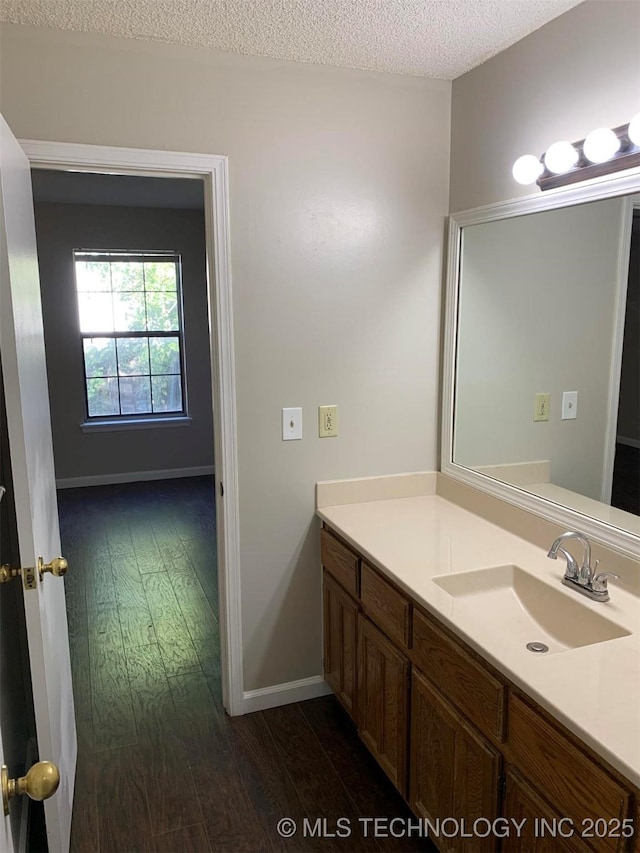 bathroom featuring hardwood / wood-style flooring, vanity, and a textured ceiling