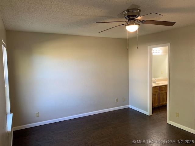 unfurnished bedroom featuring ensuite bath, a textured ceiling, dark hardwood / wood-style floors, and ceiling fan