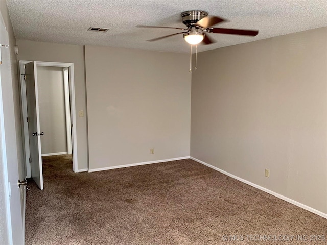 carpeted spare room featuring ceiling fan and a textured ceiling