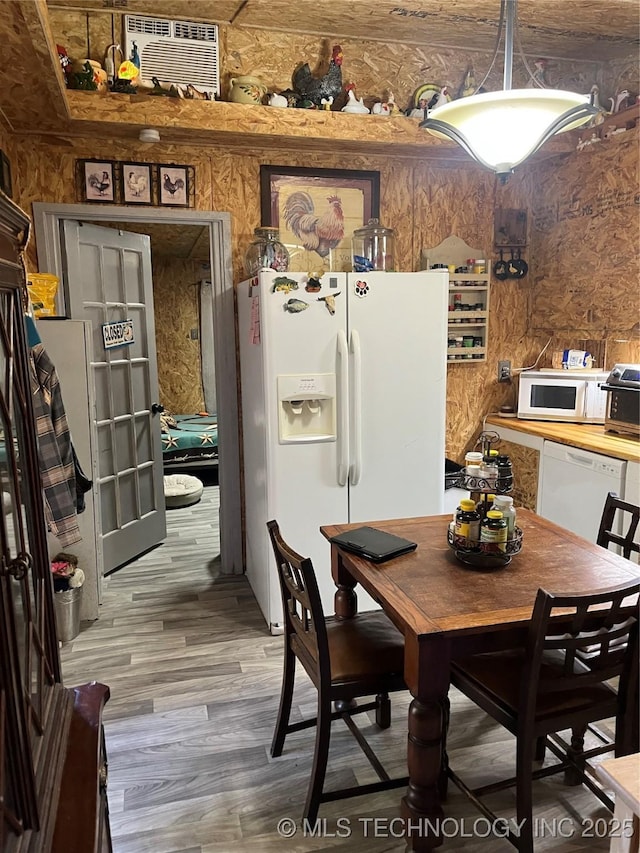 dining room featuring hardwood / wood-style flooring and wooden walls