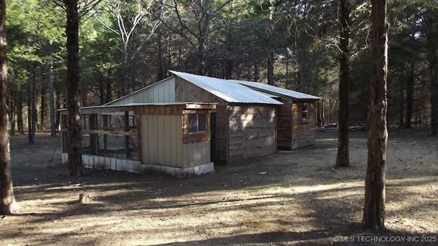 view of outbuilding featuring an outdoor structure and a wooded view