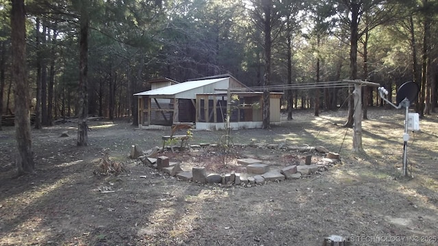 view of yard featuring an outbuilding and a view of trees