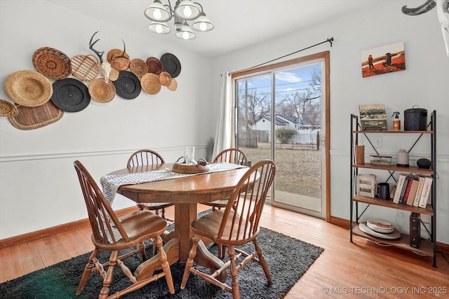 dining area featuring an inviting chandelier and light hardwood / wood-style floors