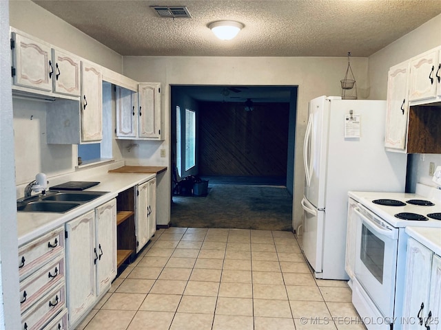 kitchen with white appliances, visible vents, white cabinets, light countertops, and a sink