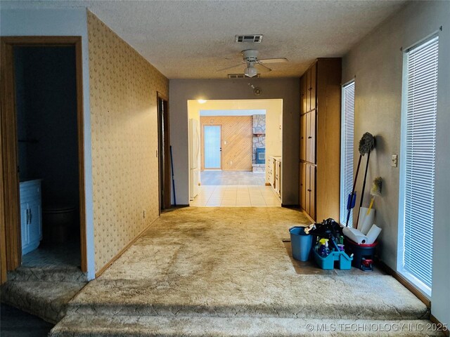 hallway featuring light carpet and a textured ceiling