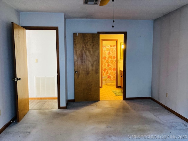 unfurnished bedroom with baseboards, visible vents, and connected bathroom