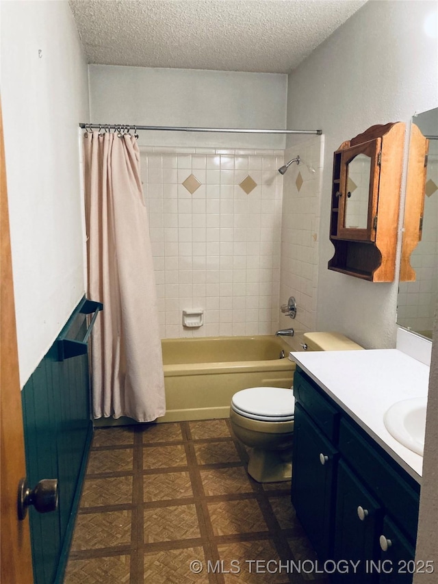 full bathroom with a textured ceiling, toilet, vanity, and shower / tub combo with curtain