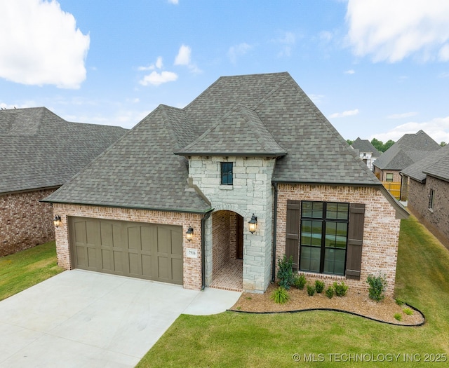 french provincial home featuring a garage and a front yard