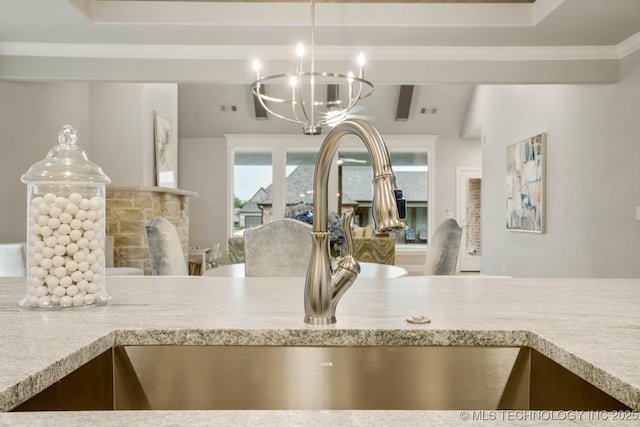 room details featuring pendant lighting, a fireplace, an inviting chandelier, ornamental molding, and beamed ceiling