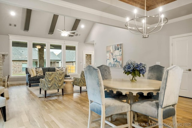 dining room with lofted ceiling with beams, light wood-style flooring, ceiling fan with notable chandelier, visible vents, and crown molding