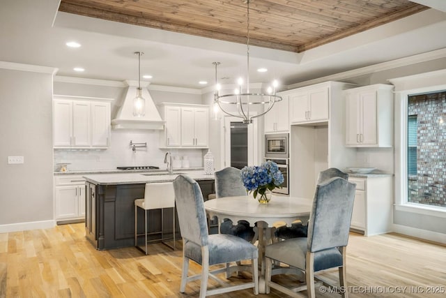 kitchen featuring white cabinetry, custom range hood, appliances with stainless steel finishes, and crown molding