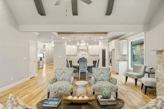 living room with baseboards, ceiling fan with notable chandelier, light wood-style flooring, and crown molding