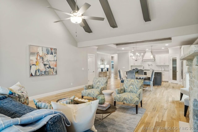 living area featuring baseboards, crown molding, light wood-style floors, high vaulted ceiling, and ceiling fan with notable chandelier