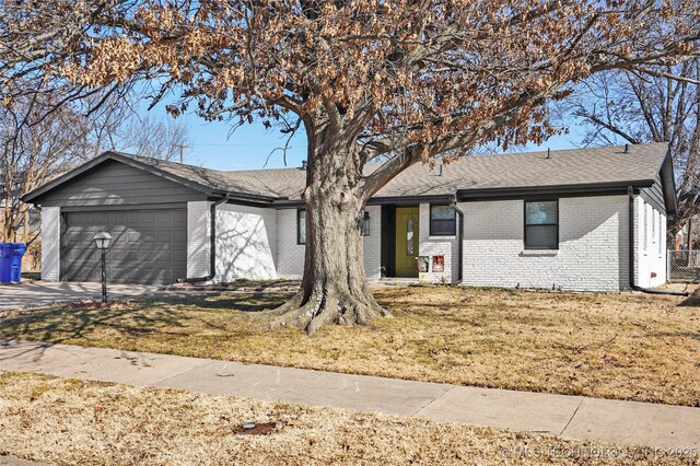 single story home featuring a garage and a front lawn