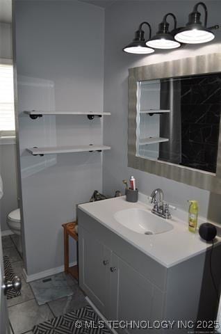 bathroom featuring tile patterned floors, toilet, and vanity