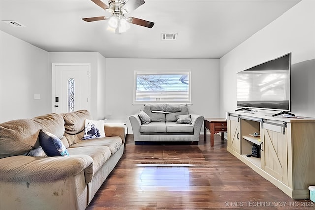 living room featuring dark wood-type flooring and ceiling fan