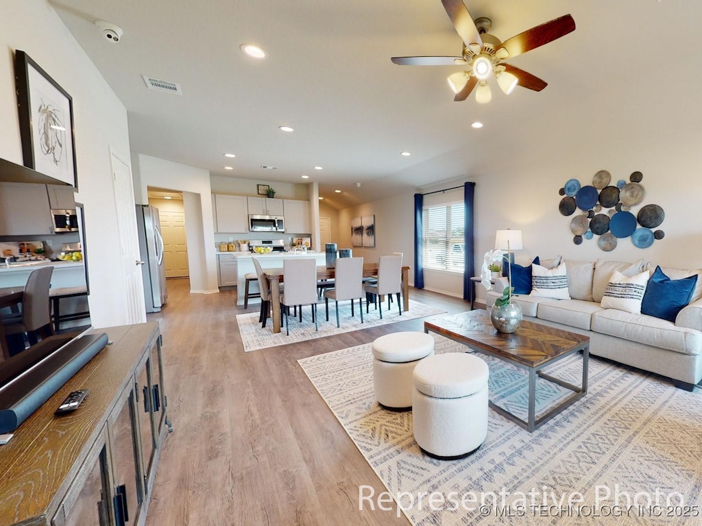 living room featuring ceiling fan and light wood-type flooring