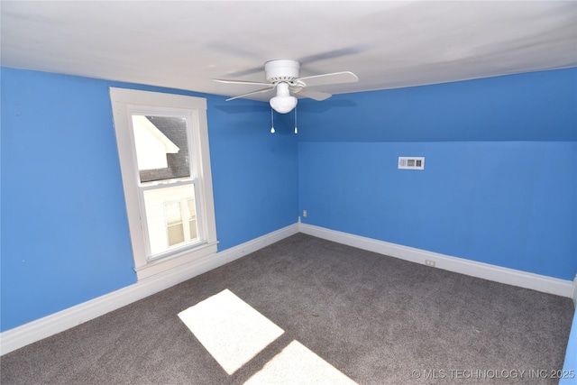 additional living space with dark colored carpet, lofted ceiling, and ceiling fan