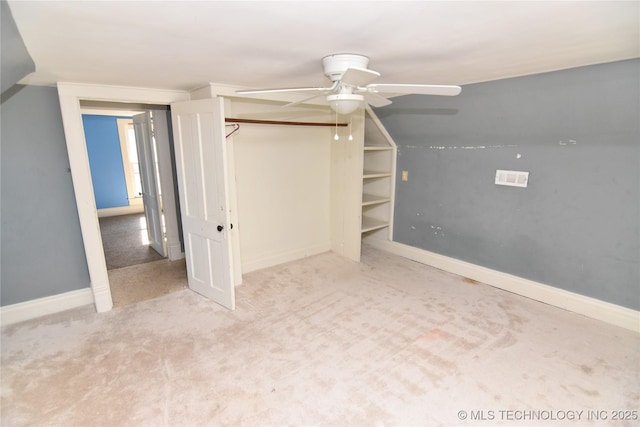 unfurnished bedroom featuring vaulted ceiling, ceiling fan, light colored carpet, and a closet