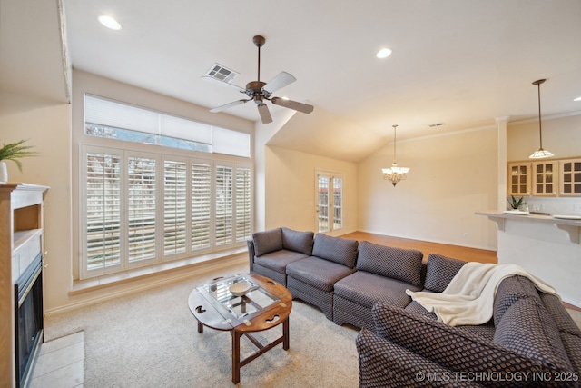 carpeted living room featuring ceiling fan with notable chandelier