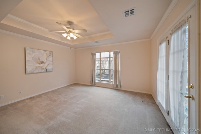 carpeted empty room with crown molding, ceiling fan, and a tray ceiling