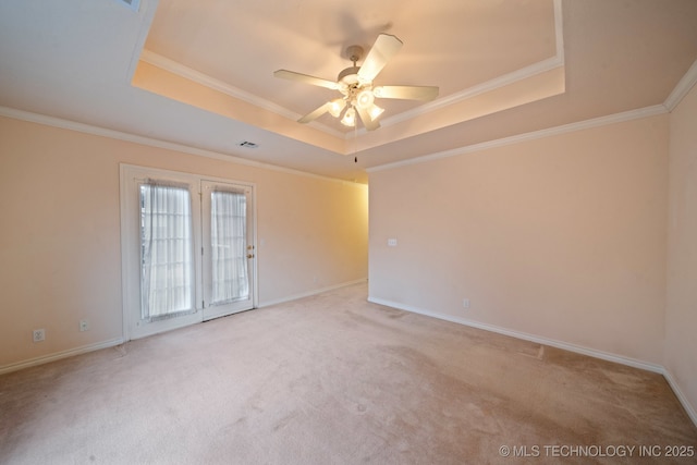 carpeted empty room with a tray ceiling, ornamental molding, and ceiling fan