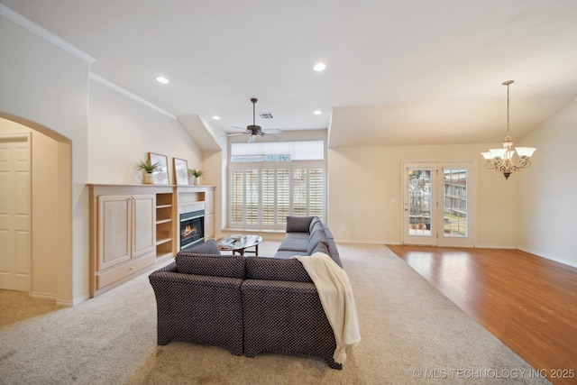 living room with crown molding, lofted ceiling, a healthy amount of sunlight, and a fireplace