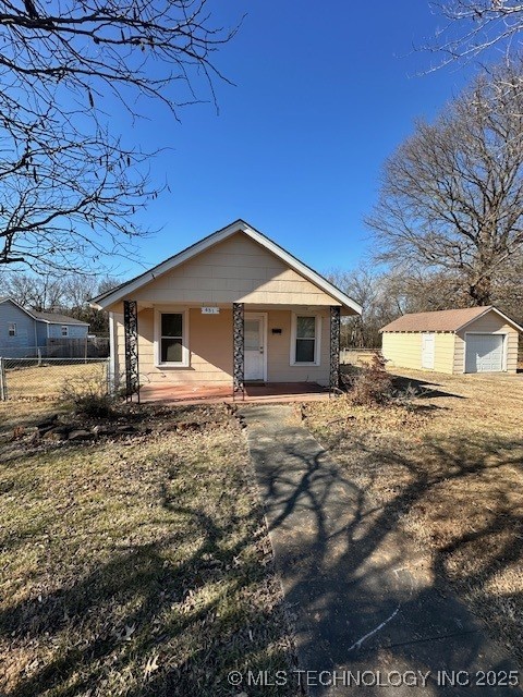 view of front of house featuring a garage, an outbuilding, and covered porch