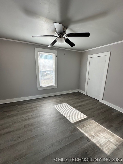 unfurnished room featuring crown molding, dark wood-type flooring, and ceiling fan