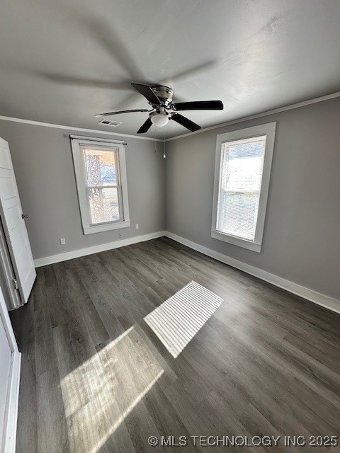 spare room with crown molding, plenty of natural light, and dark hardwood / wood-style flooring