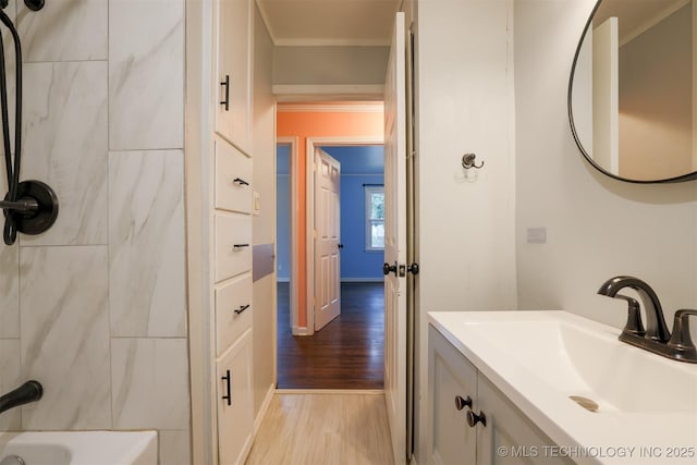 bathroom featuring ornamental molding, wood-type flooring, and vanity