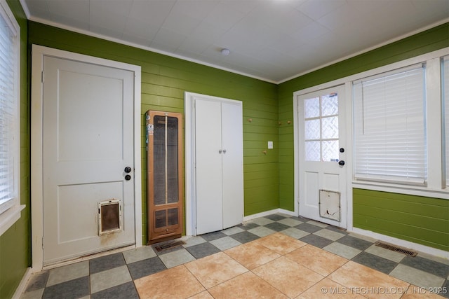 entryway with wood walls