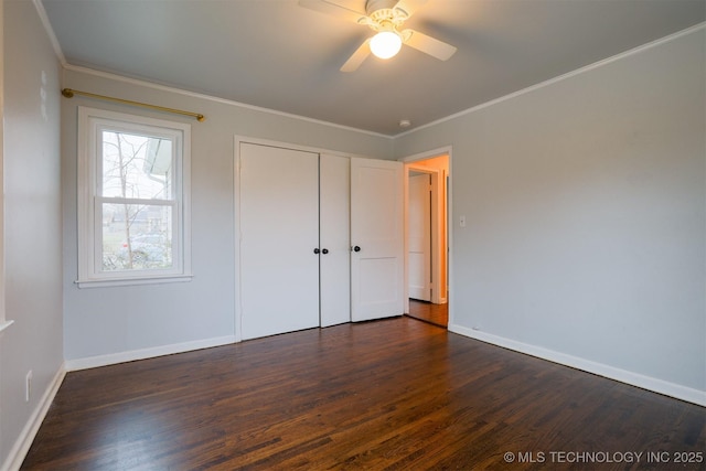 unfurnished bedroom with dark wood-type flooring, ceiling fan, ornamental molding, and a closet