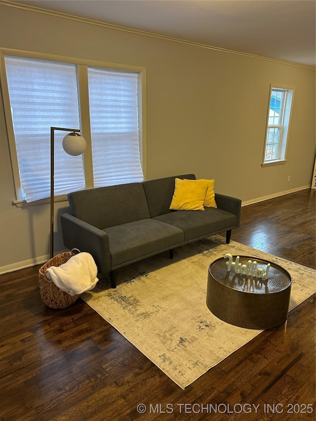 living room with dark wood-type flooring and crown molding