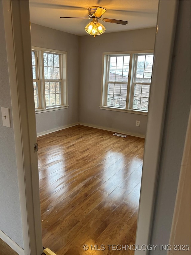 empty room featuring hardwood / wood-style floors and ceiling fan