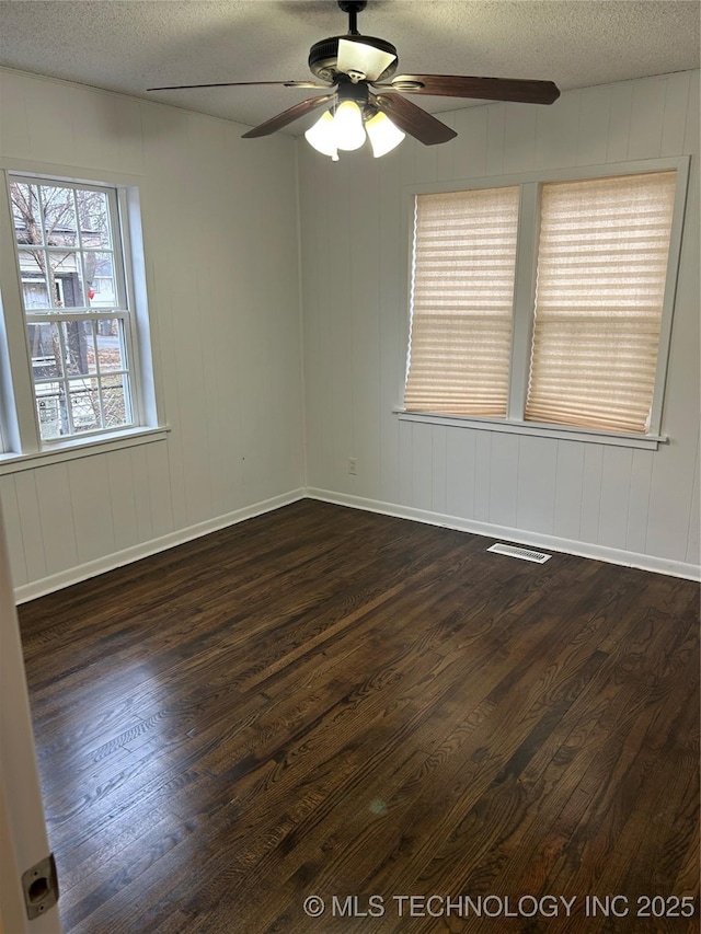 spare room with ceiling fan, dark wood-type flooring, and a textured ceiling