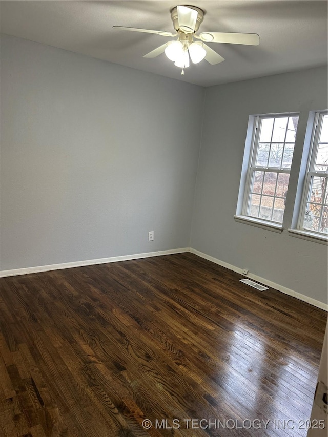 empty room with ceiling fan and dark hardwood / wood-style flooring