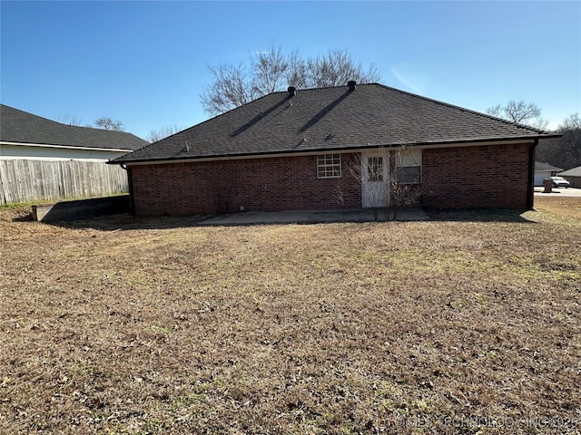 back of property with a yard and a patio area