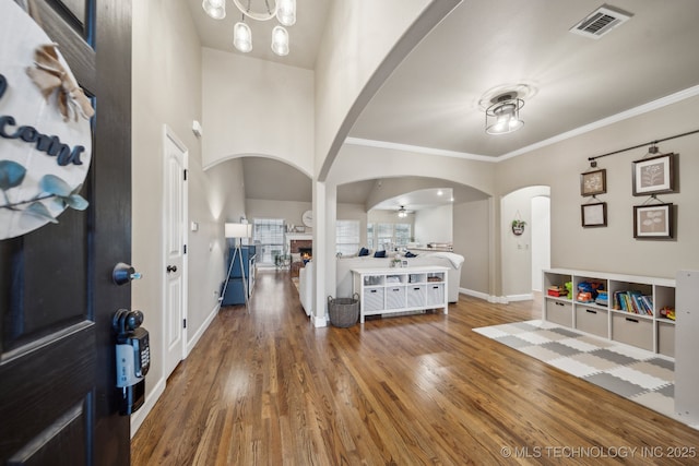 foyer with ornamental molding and wood-type flooring