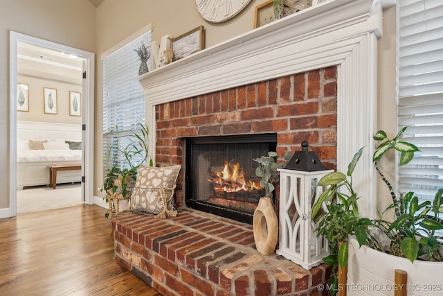 details with hardwood / wood-style flooring and a brick fireplace