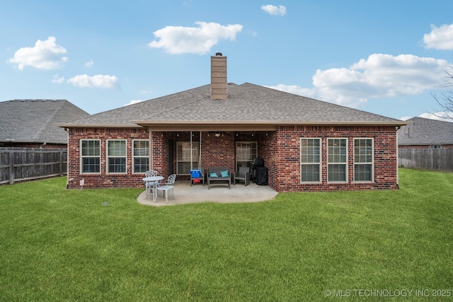 back of property with a patio area and a lawn