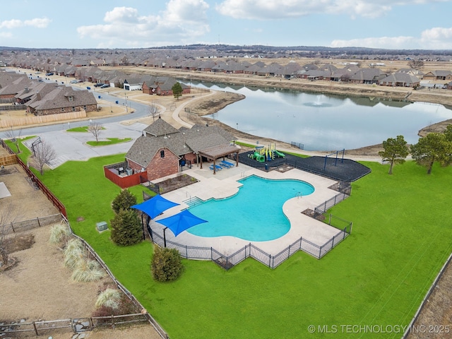 view of swimming pool with a water view and a lawn