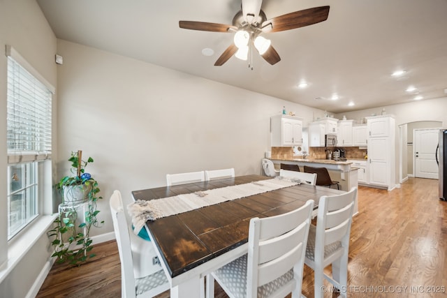 dining area with ceiling fan and light hardwood / wood-style flooring