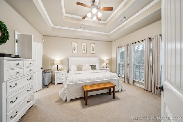 carpeted bedroom featuring ceiling fan, ornamental molding, and a raised ceiling