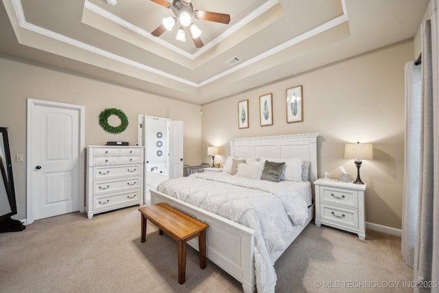 carpeted bedroom with a tray ceiling, ornamental molding, and ceiling fan