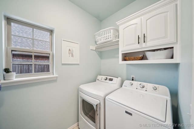 laundry room with cabinets and washing machine and clothes dryer