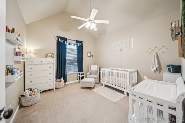 bedroom featuring a nursery area, ceiling fan, lofted ceiling, and light carpet