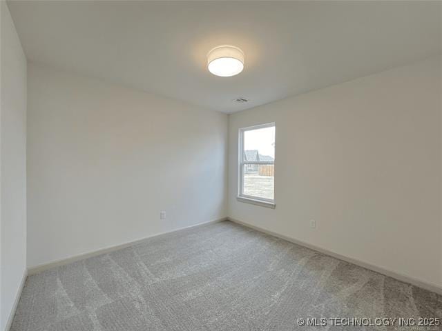 spare room featuring light colored carpet